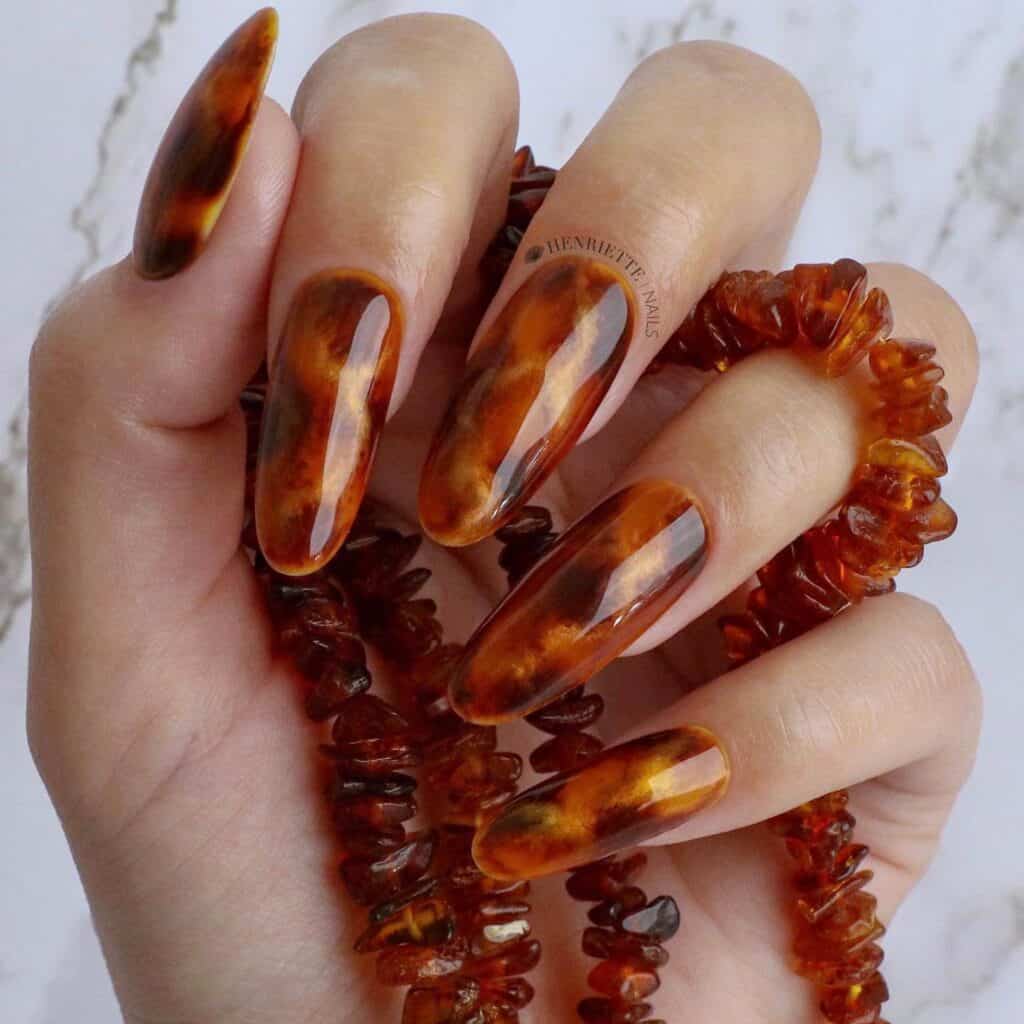 Discover the charm of amber nails with a variety of creative designs, from gel to acrylic styles. Find inspiration for your next manicure.