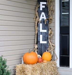 Fall Pallet Sign with pumpkins on top of hay bales