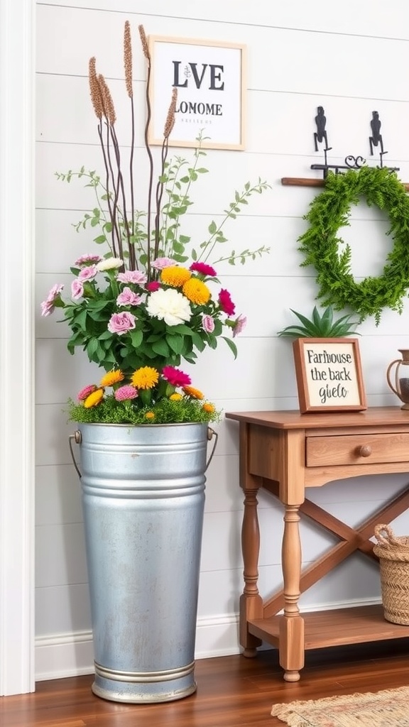 An entryway featuring a galvanized metal bucket planter filled with colorful flowers, a wooden table with decorative items, and a wall art piece.